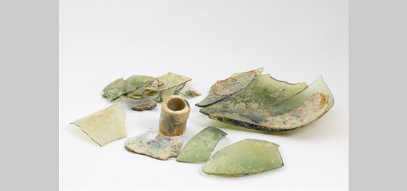 Deze fragmenten waren ooit een glazen kolf. Deze maatbeker werd vermoedelijk gebruikt in het laboratorium in een van de bijgebouwen. Hier werden kogels gemaakt.